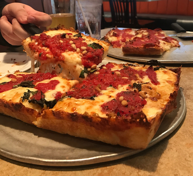 Serving Detroit style pizza