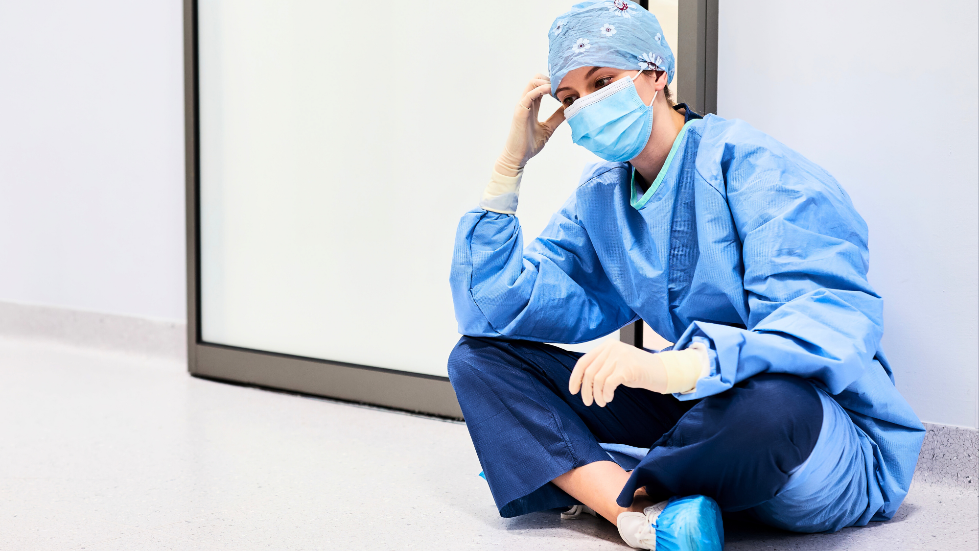 Nurse in PPE sitting in the hallway