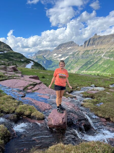 Travel nurse standing on a rock in a beautiful mountain stream.