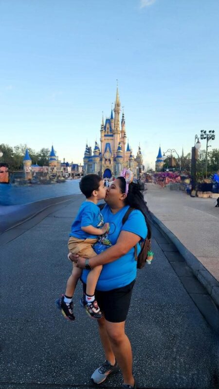 Travel nurse and child at Disneyland with caste in the background.