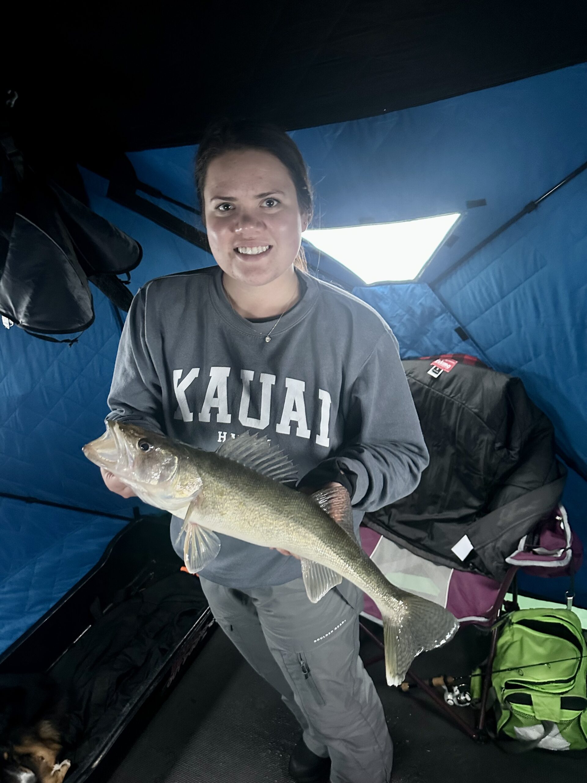 Girl standing in tent holding fish