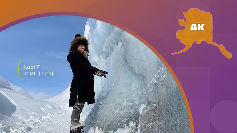 Girl in coat standing next to glacier in Alaska