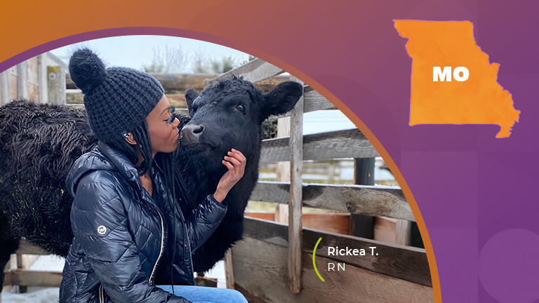 A girl kissing a black cow on a farm in missouri