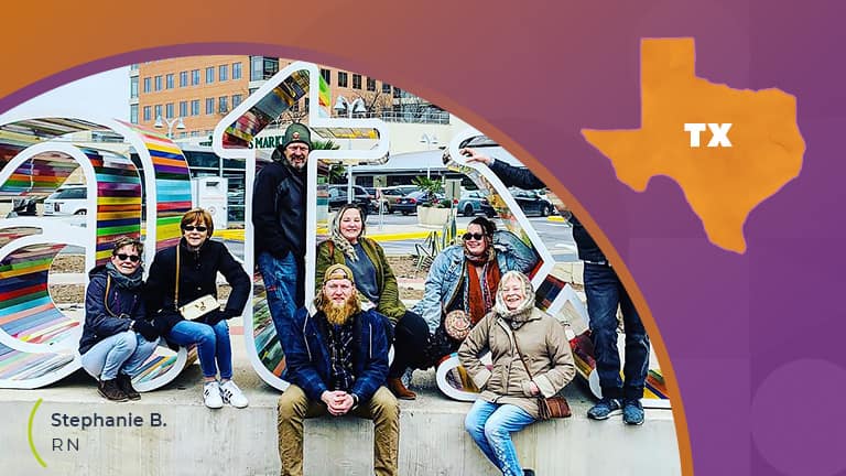 A group of people sitting in front a giant texas sign