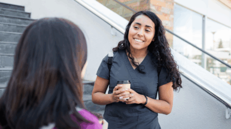 a-smiling-woman-in-scrubs-talking-to-another-woman