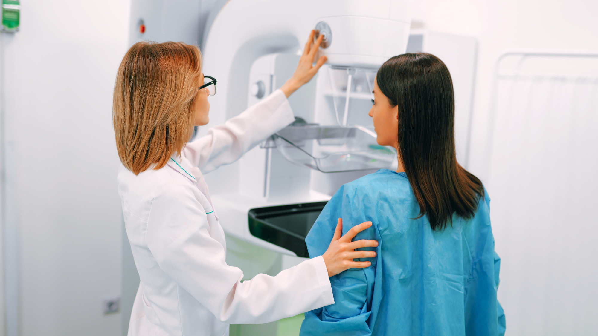 A female mammographer doing an exam on a female patient.