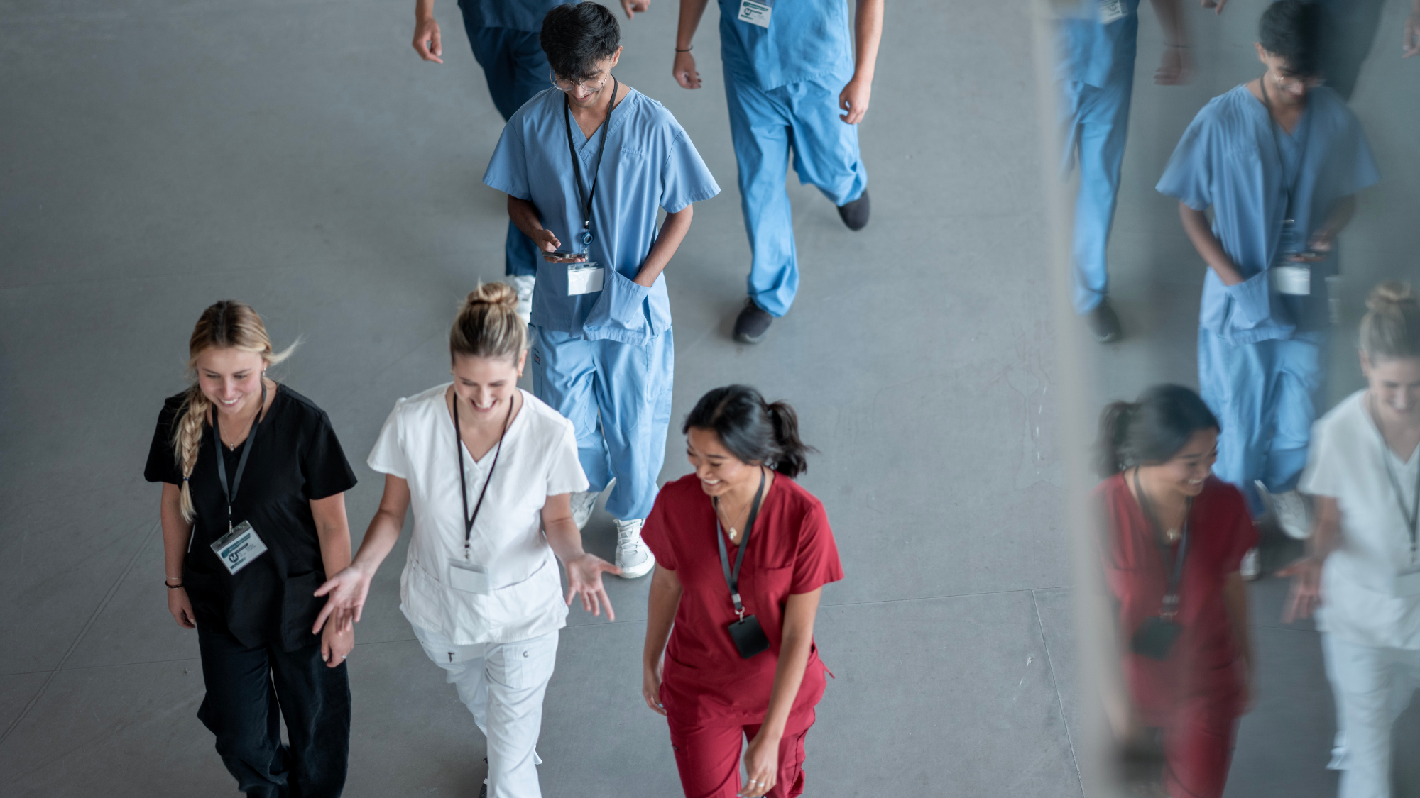 Contingent clinicians smiling and walking together, representing happy and engaged clinicians thanks to workforce innovation from healthcare workforce solutions partner