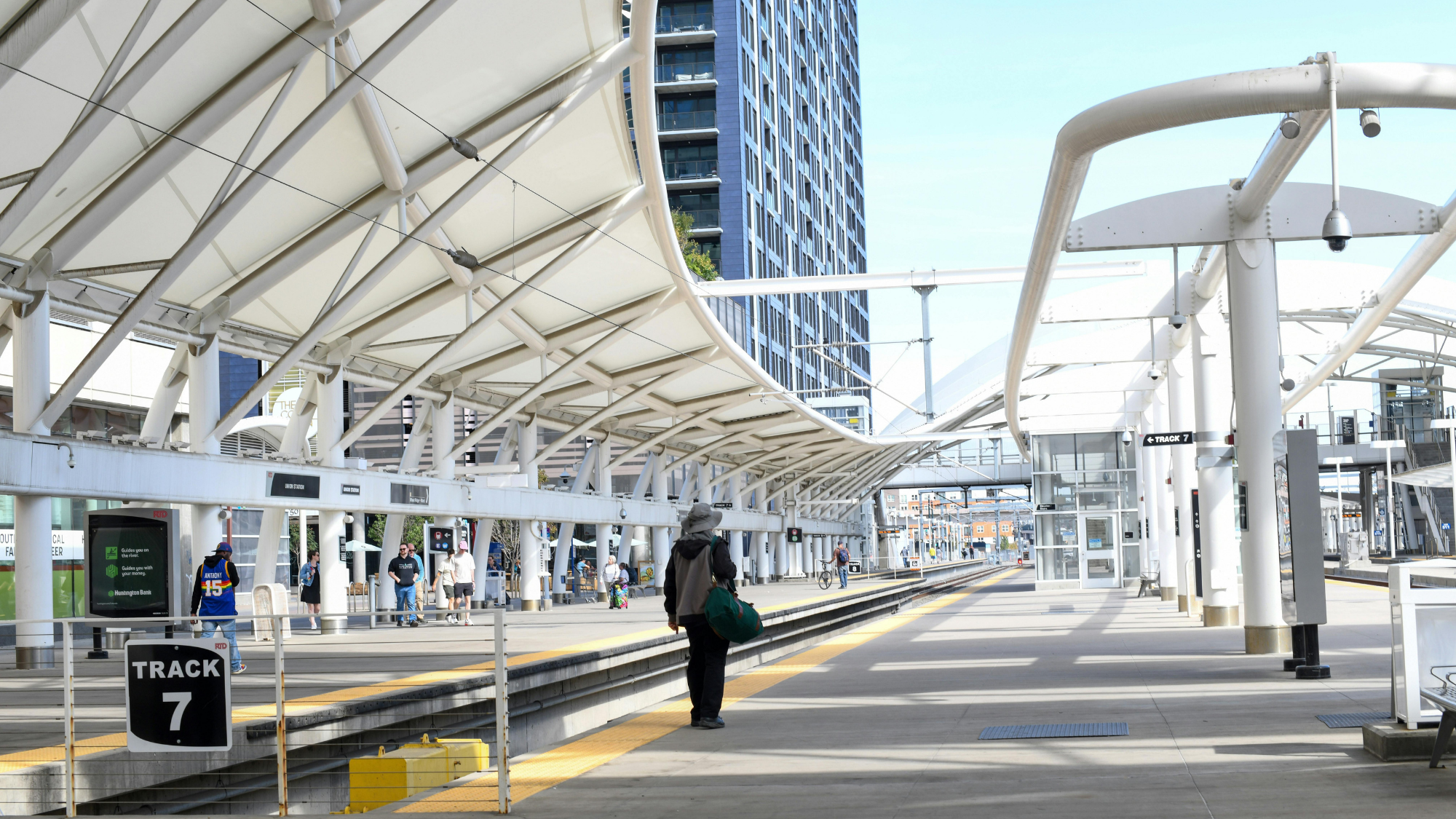 Man walking next to a downtown city train track.