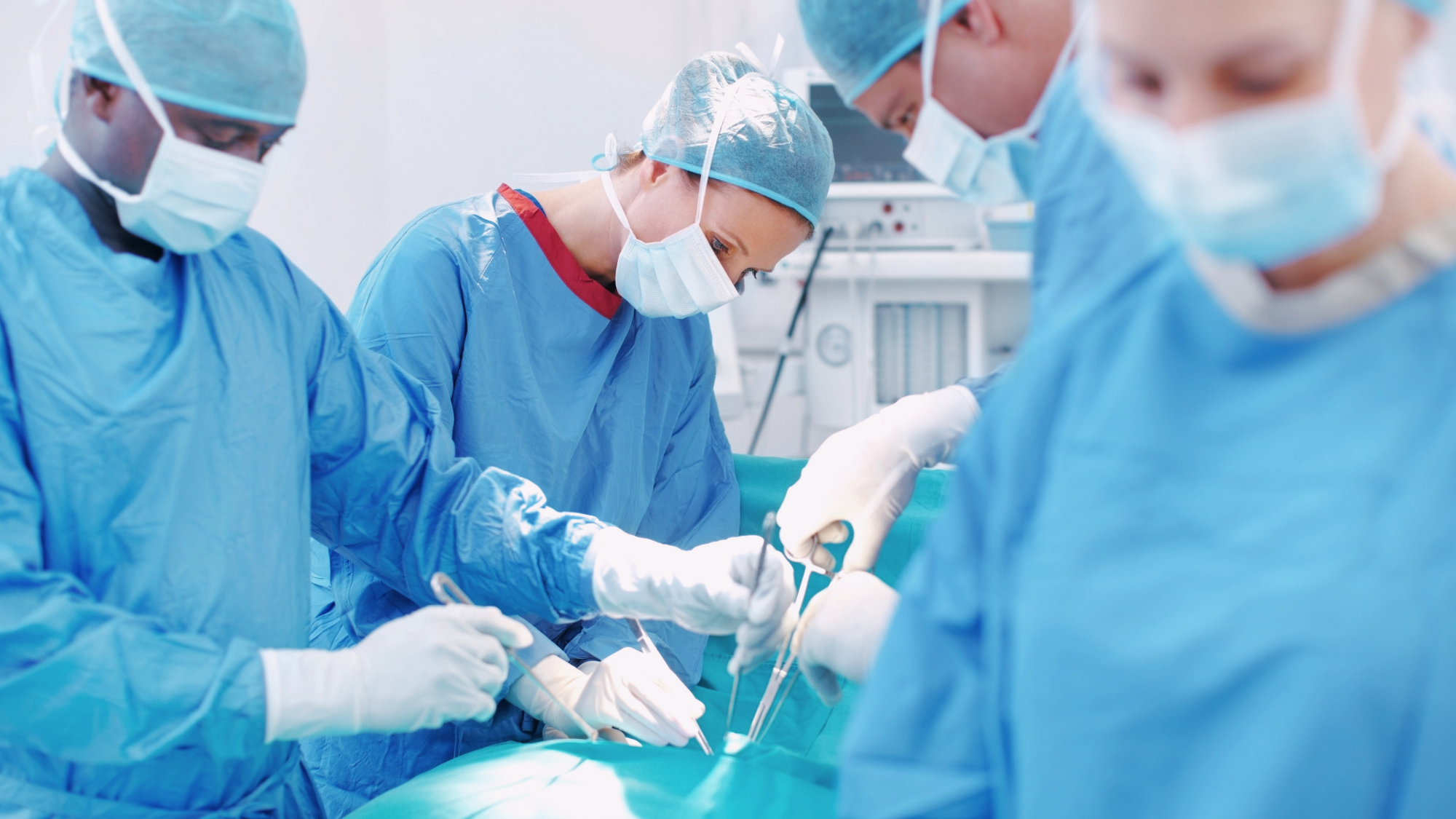Doctors and nurses operating on a patient.
