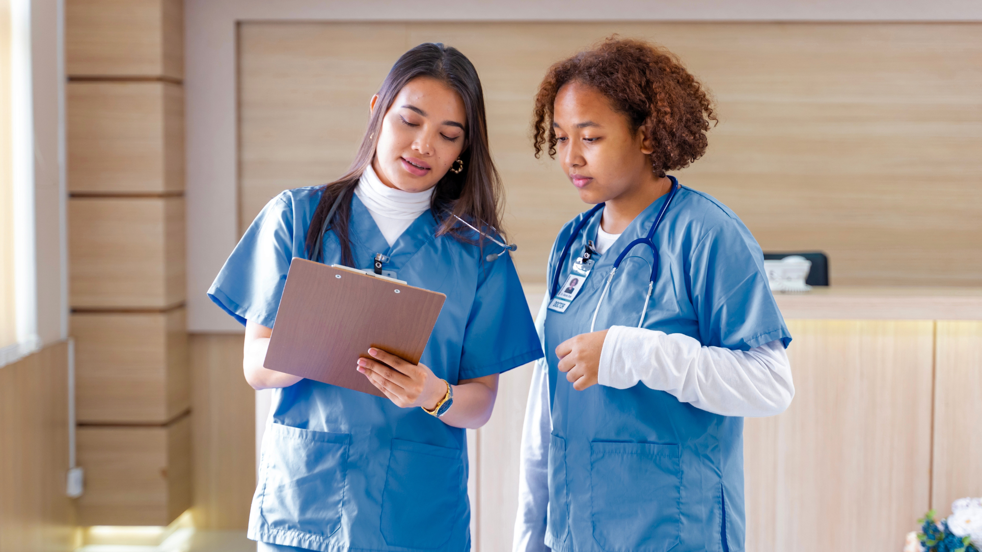 Two women nurses looking at a chart together.