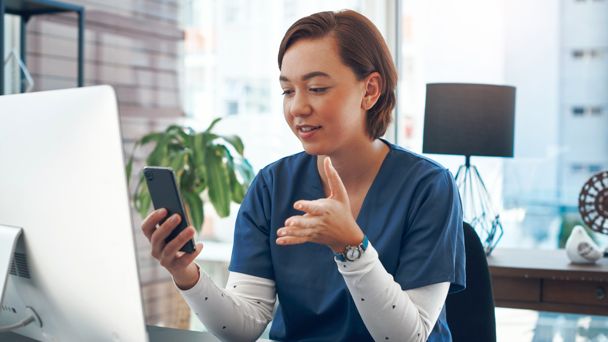 Female nurse sitting at a desk doing a telehealth visit